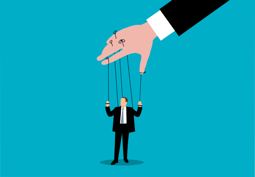 llustration dâun homme en costume manipulĂ© comme une marionnette par une main gĂ©ante, symbolisant la pression de certains clients sur les freelances ou prestataires.