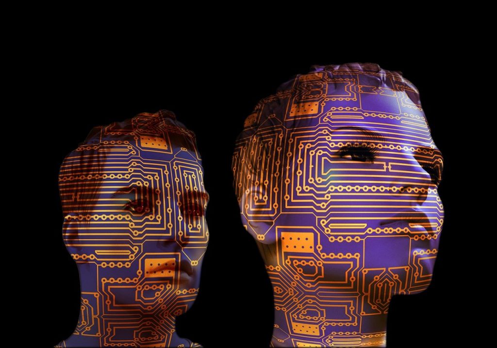 Deux visages humains sur fond noir recouverts de circuits imprimés orange et violets, symbolisant la fusion entre intelligence humaine et intelligence artificielle.